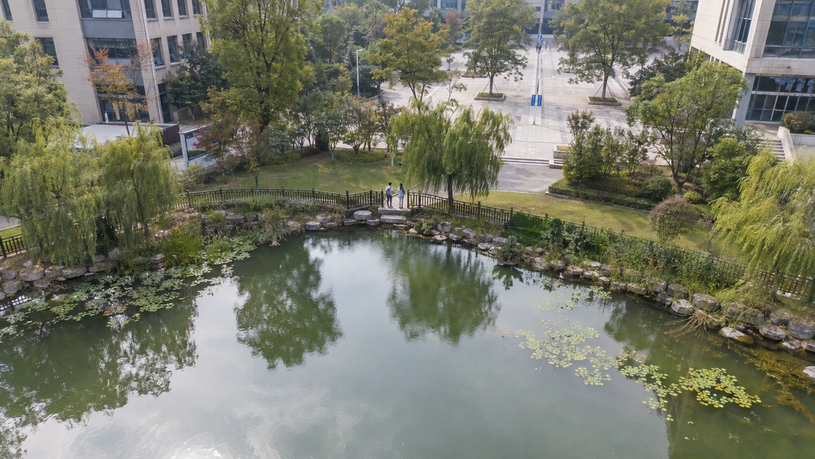 校园临水危险区域活动巡查：独立无人机航拍场景与红色目标标注示意